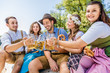 © karepa - Freunde in bayerischen Tracht feiern an der Isar und trinken Bier. Oktoberfest München