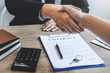 © Ngampol - Finishing to successful deal of real estate, Broker and client shaking hands after signing contract approved application form, concerning mortgage loan offer for and house insurance