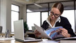 Irresponsible female employee reading magazine in office, avoiding tedious work