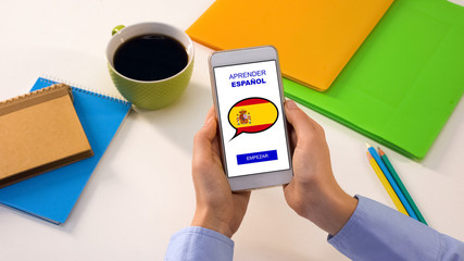 Spanish language application on smartphone in persons hands, online education
