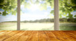 © magdal3na - Table background and spring time. Green garden outside the winfow in blurred view. Empty space for decoration and an advertising product.