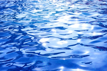 the surface of the water in the pool with bright sun highlights