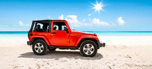 A Red Jeep On Sandy Beach And Beuatiful Blue Sunny Sky View In Summer Time.