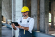 © cherryandbees - worker in protective wear using tablet on construction site