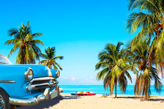 Wall Mural -  - The tropical beach of Varadero in Cuba with american classic car, sailboats and palm trees on a summer day with turquoise water. Vacation background.