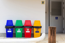 Set Of Various Colorful Garbage Bins Located On The Cement Floor In Front Of The Toilet. Trash Containers For Garbage Sorting.
