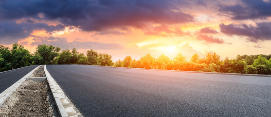 Asphalt highway and green forest with beautiful cloud landscape at sunset