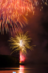 Colorful fireworks. Fireworks are a class of explosive pyrotechnic devices used for aesthetic and entertainment purposes. Visible noise due to low light, soft focus, shallow DOF, slight motion blur