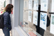 © OceanProd - woman in front of the window of a real estate agency