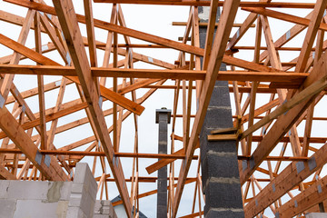 Wall Mural - System chimney on a detached house under construction, visible chimney block and elements of roof trusses.