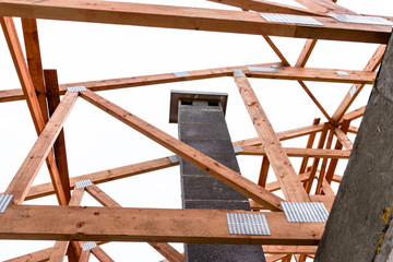 Wall Mural - System chimney on a detached house under construction, visible chimney block and elements of roof trusses.