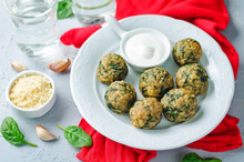 Cheese Spinach Balls With Spinach Leaves And Greek Yogurt Sauce