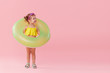 © oes - Portrait of happy little girl with neon inflatable rubber circle having fun isolated on pink background. Space for text on right side