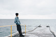 © Alina Hvostikova/Stocksy - Stylish female standing on wet pier
