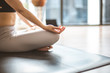 © anon - Young woman practicing yoga in  gray background.Young people do yoga indoor at home.