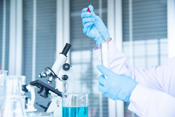 Wall Mural - Closed up Asian woman scientist, researcher, technician, or student's hand conducting research in laboratory