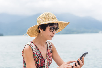 Poster - woman with hat sit at a pier using cellphone