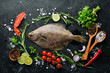 Raw flounder fish with spices. Seafood on a black stone background. Top view. Free copy space.