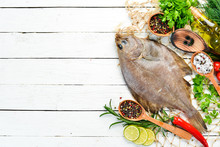 Raw Flounder Fish With Spices. Seafood On A White Wooden Background. Top View. Free Copy Space.