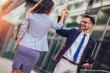 Smiling business colleagues greeting each other outdoors