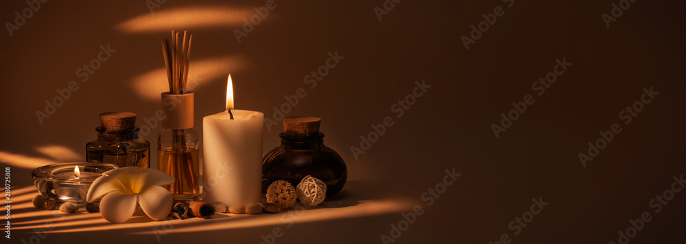 Beautiful spa composition with candles, frangipani flower, oil flasks and other decor elements. - obrazy, fototapety, plakaty 