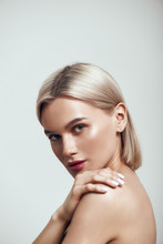 Perfection. Vertical Photo Of Sexy Young Woman With Blond Hair And Perfect Shiny Skin Looking At Camera While Standing Against Grey Background