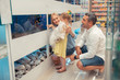 © Viacheslav Yakobchuk - Girl with fluffy dog looking at aquarium with mom and dad