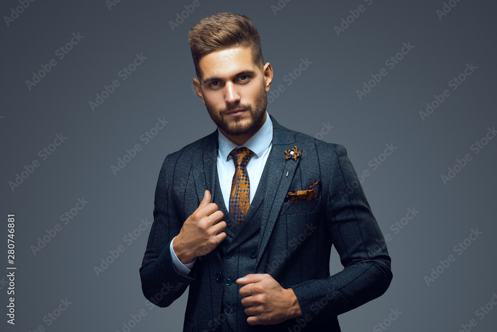 Stylish young man in suit and tie. Business style. Fashionable image. Office worker. Sexy man standing and looking at the camera - obrazy, fototapety, plakaty 