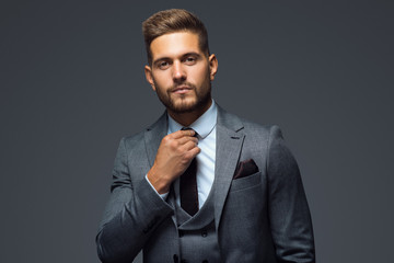 Stylish young man in suit and tie. Business style. Fashionable image. Office worker. Sexy man standing and looking at the camera