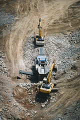 Excavator loading dumper truck on mining site stock photo