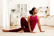 © Anatoliy Karlyuk - Horizontal image of sporty stylish young Afro American woman in sports clothes practicing yoga, sitting on mat with one knee bent, turning head. Healthy lifestyle, wellbeing and activity concept