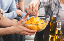 Man Holding Bowl With Chips Sharing With Friends At Party