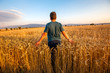 © Kerim - Farmer in a field of wheat at sunset