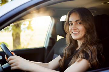 Wall Mural - Happy female student driving car just after receiving car license, happy to pass driving exam and drive car by herself