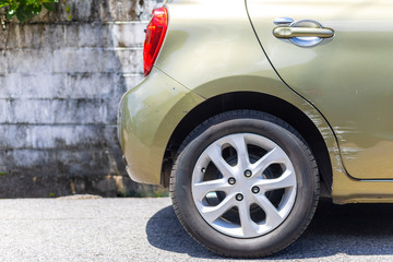 Car crash. Beside the deep green color car have scratch from damage on road. Close up scratch.