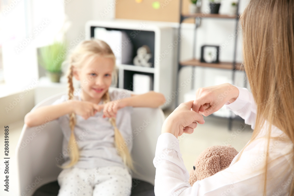 Mother teaching her deaf mute daughter to use sign language at home