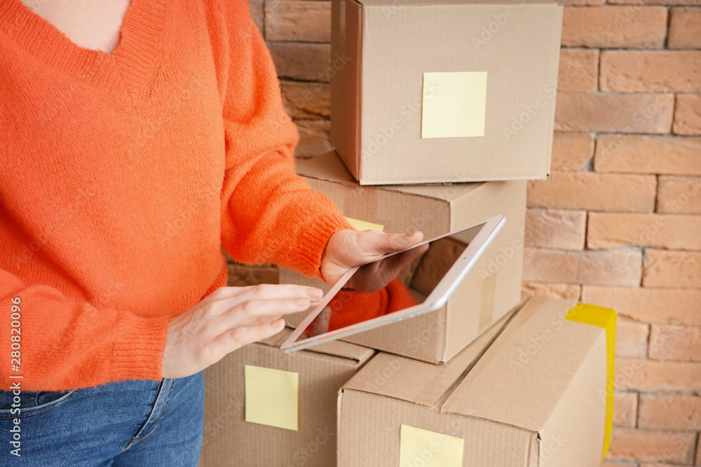 Young woman with tablet computer and parcels, closeup