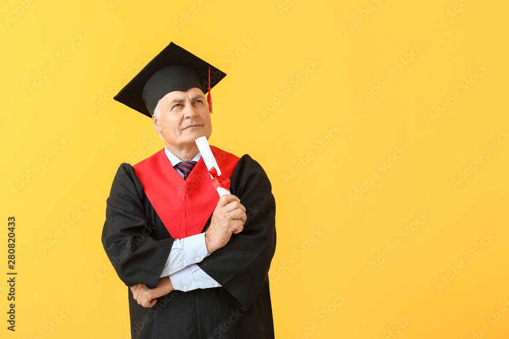 Thoughtful mature man in bachelor robe on color background