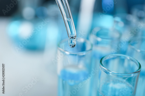 Fotografía Dripping liquid into test tube, closeup with space for text