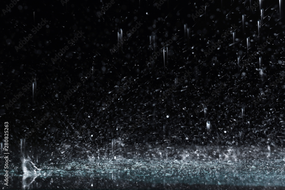 Heavy rain falling down on ground against dark background - obrazy, fototapety, plakaty 
