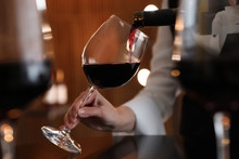 Waitress Pouring Wine Into Glass In Restaurant, Closeup