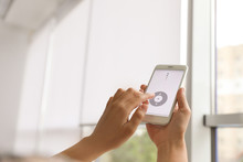 Woman Using Smart Home Application On Phone To Control Window Blinds Indoors, Closeup. Space For Text