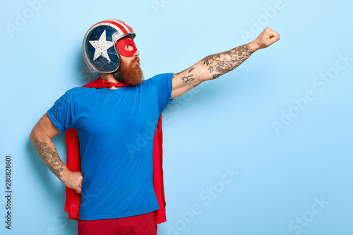 Fotomural Profile shot of serious bearded man makes flying gesture, looks into distance, w