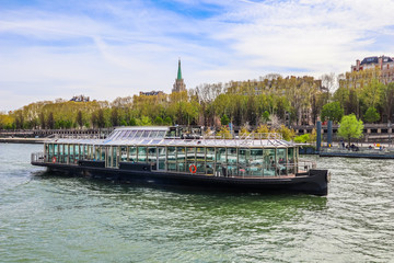 Tourist boat on the Seine river in spring. Paris, France. April 2019