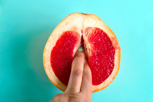 Two Fingers In A Grapefruit Isolated On A Blue Background Top View Sex Concept