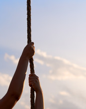 Young Woman Or Girl Holds Hands On Rope And Climbs Up In Physical Education Class.
