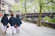Japanese woman family wearing kimono and walking at Kinosaki Onsen village street in Toyooka City, Hyogo, Japan. See from back side in morning. Japan traveler trip.