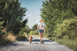 © encierro - Woman and dog walking on road. Tourist with backpack enjoying walk with her animal best friend