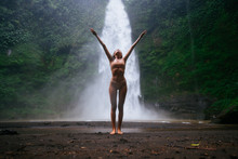 Beautiful Girl Having Fun At The Waterfalls In Bali. Concept About Wanderlust Traveling And Wilderness Culture