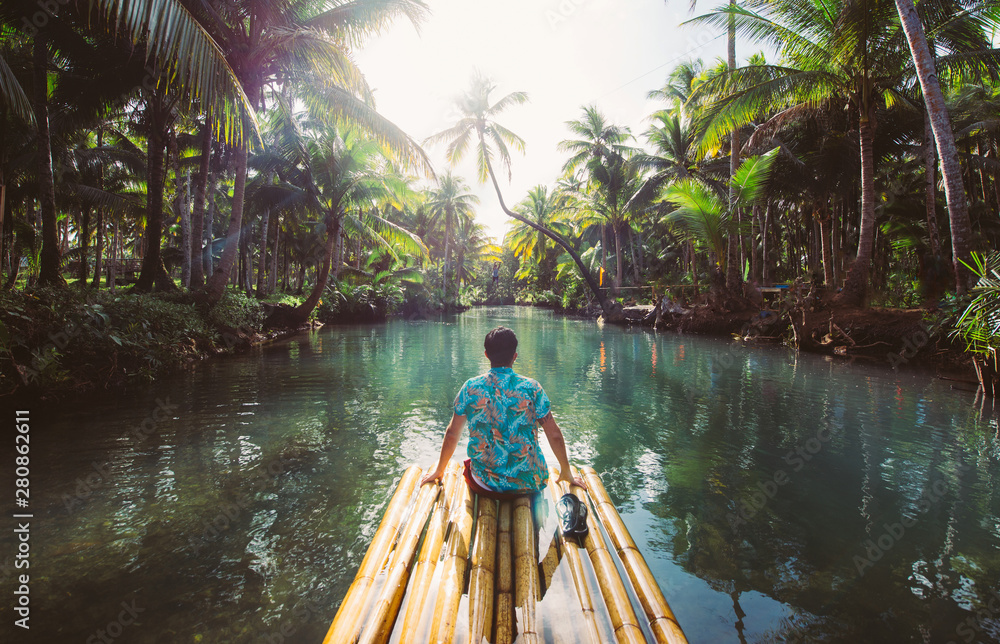 Palm tree jungle in the philippines. concept about wanderlust tropical travels. swinging on the river. People having fun - obrazy, fototapety, plakaty 